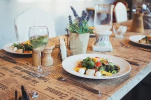 A glass of white wine served with a crisp, fresh salad