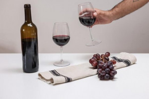 An image of two glasses and a bottle of red wine